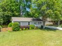 Charming single-story home with well-maintained lawn, mature trees, and inviting front porch at 21614 Colina Dr, Cornelius, NC 28031