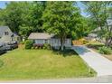 Well-kept lawn with mature trees and long driveway leading to a charming single-story home at 21614 Colina Dr, Cornelius, NC 28031
