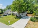 Charming single-story home with a lengthy driveway and a lush front yard, complemented by mature trees at 21614 Colina Dr, Cornelius, NC 28031