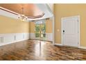 Sunlit dining area with hardwood floors, decorative ceiling, wainscoting, and a view of the front yard at 2346 Donnington Nw Ln, Concord, NC 28027