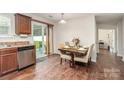 Bright dining area with wood floors, sliding glass doors, and modern lighting at 2423 Dewey Creek Ln, Charlotte, NC 28216