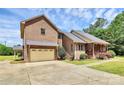 The side view of the exterior showcases the brick facade, large garage, and cozy front porch at 261 Melrose Sw Dr, Concord, NC 28025