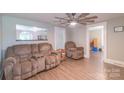 Cozy living room featuring plush seating, ceiling fan, and wood-look laminate flooring at 28782 Canton Rd # A, Albemarle, NC 28001