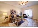 Cozy living room featuring wood floors, a ceiling fan, and ample natural light at 3055 Golden Dale Ln # 104, Charlotte, NC 28262