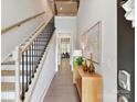 Bright foyer featuring hardwood floors, staircase with black railings, and stylish decor at 3135 Everly Enclave Way, Charlotte, NC 28210