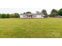 Traditional single-story home with a covered porch, landscaped yard, and a detached carport for extra parking at 404 St Lukes Church Rd, Kings Mountain, NC 28086