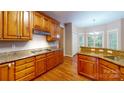 Traditional kitchen featuring wood cabinetry, granite countertops, and hardwood flooring at 4066 Belle Meade Cir, Belmont, NC 28012