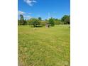Sprawling green yard with mature trees, a bird bath, and charming wooden well feature at 4122 Canal Rd, Marshville, NC 28103