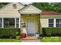 Inviting front door with decorative metal accents, surrounded by well-manicured hedges and vibrant potted plants at 509 S Clay St, Gastonia, NC 28052