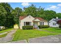 Charming yellow bungalow with red roof, well-kept lawn, and detached garage, perfect for storage and parking at 509 S Clay St, Gastonia, NC 28052