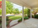 Covered front porch featuring white columns and a view of the beautifully landscaped front yard at 533 Montgrove Nw Pl, Concord, NC 28027