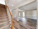 Bright and spacious living room features gray wood floors, columns, and a staircase on the side at 533 Montgrove Nw Pl, Concord, NC 28027