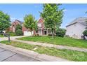 A lovely brick home with a two-car garage surrounded by a green lawn and mature shade trees at 6227 Castlecove Rd, Charlotte, NC 28278