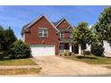 Charming two-story brick home with a well-manicured lawn and attached two-car garage at 6227 Castlecove Rd, Charlotte, NC 28278
