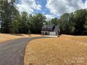 Charming two-story home with a paved driveway and lush greenery providing a private setting at 910 Westminster Dr, Statesville, NC 28677