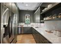 Stylish kitchen with modern stainless steel appliances, hardwood floors, and open shelving storage space at 922 Everett Pl, Charlotte, NC 28205