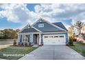 Charming single-Gathering home with blue siding, stone accents, a two-car garage, and manicured lawn at 106 S Inneswood Ln # 31, Mooresville, NC 28115