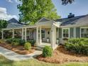 Inviting home with a charming covered porch, featuring classic columns and professionally landscaped surroundings at 1069 Sedgefield Rd, Charlotte, NC 28209