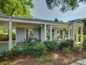 Covered patio area with an outdoor dining set, perfect for entertaining in a serene, landscaped setting at 1069 Sedgefield Rd, Charlotte, NC 28209