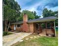 Rear exterior view of a single-story brick home featuring a spacious covered patio at 128 Paul Snipes Rd, Lancaster, SC 29720