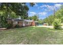 Spacious lawn surrounds this single story house, brick chimney, and covered porch at 128 Paul Snipes Rd, Lancaster, SC 29720