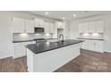Modern kitchen featuring white cabinets, stainless steel appliances, a large island, and dark countertops at 15004 Meadows Hunt Ln # 155, Huntersville, NC 28078