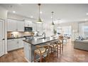 Gourmet kitchen features stainless steel appliances, white cabinets, and an island with bar seating, open to the living area at 15008 Meadows Hunt Ln # 156, Huntersville, NC 28078