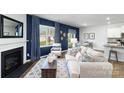 Stylish living room with a fireplace, blue accent wall, and an adjacent dining area at 151 Rustling Waters Dr, Mooresville, NC 28117
