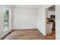 Light and airy dining room features detailed wall trim, hardwood floors, and large windows at 15108 Castlebridge Ln, Matthews, NC 28104