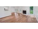 Spacious living area with fireplace, hardwood flooring, and a seamless transition to the kitchen at 15108 Castlebridge Ln, Matthews, NC 28104