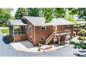 Brick home featuring a deck, screened porch, and landscaped backyard at 1602 Brentwood Dr, Newton, NC 28658