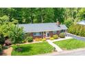 Aerial view of a brick home featuring a charming front yard with mature trees at 1602 Brentwood Dr, Newton, NC 28658
