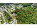 Aerial view of a property outlined in red with surrounding neighborhood with a tree-filled landscape at 17416 Gillican Overlook Rd, Davidson, NC 28036