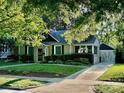 Bungalow-style home featuring a detached garage, lush lawn and mature trees providing ample shade and curb appeal at 1809 The Plaza None, Charlotte, NC 28205