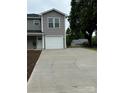 A long concrete driveway leads to a well-maintained home with neutral gray siding and white trim at 2012 Crown Point Dr # A, Albemarle, NC 28001