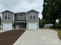 Exterior shot showcasing two modern townhomes with gray siding, white trim, and well-manicured yards and driveways at 2012 Crown Point Dr # A, Albemarle, NC 28001