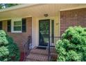Close up of the brick ranch style house with dark shutters and landscaping at 227 Country Club Cir, Shelby, NC 28150