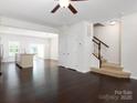 View of living room featuring dark wood floors, stairs and an entrance to the kitchen at 2448 Mariners Cove Ln, Denver, NC 28037