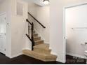 Carpeted stairs with a wood railing leading to the upper level at 2448 Mariners Cove Ln, Denver, NC 28037