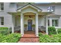 A welcoming front porch featuring porch swings, brick flooring, and classic white columns at 2627 Hampton Ave, Charlotte, NC 28207