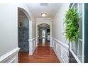 Elegant hallway with hardwood floors, decorative molding, and arched doorways leading to other living spaces at 3664 Privette Rd, Matthews, NC 28104