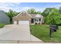 Beautiful brick home features a two-car garage, well-manicured lawn, and welcoming front porch on a sunny day at 3817 Arial Ln # 145, York, SC 29745