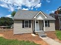 Inviting home featuring neutral siding and black shutters surrounded by a manicured lawn at 406 4Th St, Spencer, NC 28159