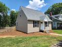 Well-maintained home with neutral siding, black shutters, and a charming fenced yard at 406 4Th St, Spencer, NC 28159
