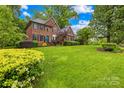 Charming two-story brick home with lush landscaping, a vibrant lawn, and a bright blue front door at 4339 Shannamara Dr, Matthews, NC 28104
