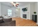 Cozy living room with hardwood floors, fireplace, and modern ceiling fan at 461 Hurston Cir # 51, Charlotte, NC 28208