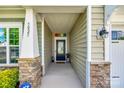 Inviting covered front porch with stone pillars and a glass-paneled front door with secured entrance at 5025 Kinross Ln, Indian Land, SC 29707