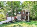 Charming brick two-story home with a well-manicured lawn and mature trees at 516 Aspen Ln, Indian Trail, NC 28079