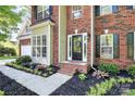 Beautiful front door and landscaping featuring a brick home exterior and mature trees at 516 Aspen Ln, Indian Trail, NC 28079