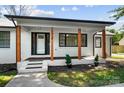 Inviting front porch features natural wood posts, black trim, and stylish landscaping, providing curb appeal at 5428 Barnsdale Ln, Mint Hill, NC 28227